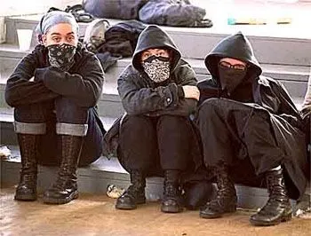 Anarcho-Punk aesthetic — The monochrome black, bandanas/balaclavas, and combat boots strongly evoke the uniform-like, politically charged look of Anarcho-Punk.
