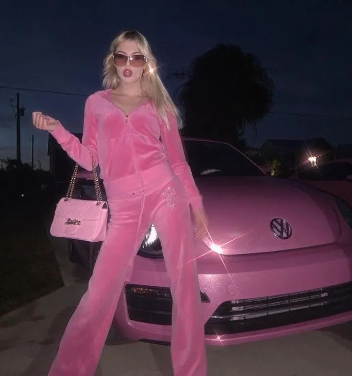 Bimbocore aesthetic — The full Juicy Couture velour tracksuit in hot pink, paired with a micro bag and sparkly details, perfectly embodies the Bimbocore aesthetic's iconic brand and color palette.