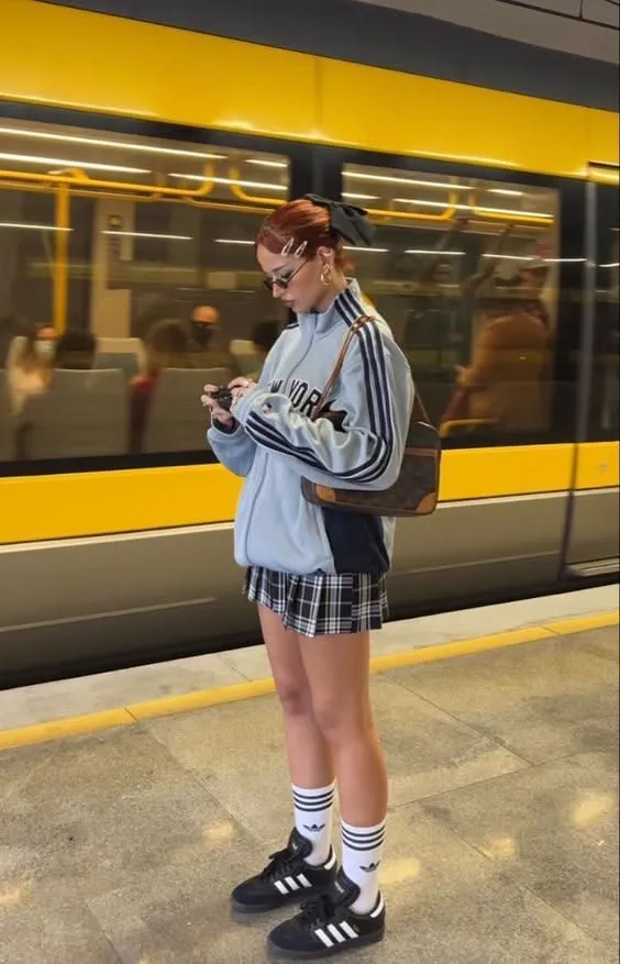 Blokette aesthetic — Vintage track jacket, plaid mini skirt, knee-high socks, and Adidas Sambas are signature pieces.