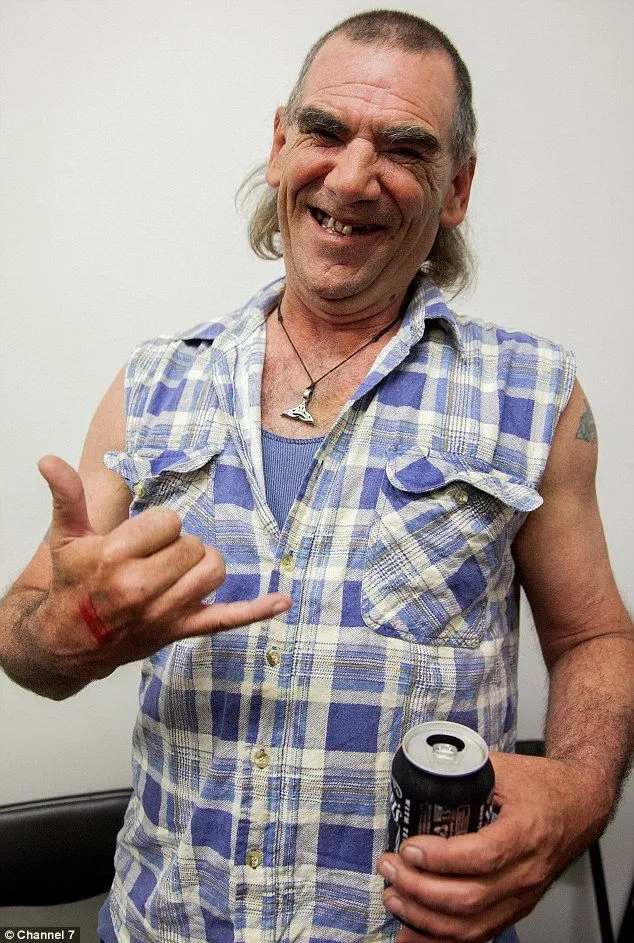 Bogan aesthetic — The mullet, sleeveless flannel shirt over a singlet, and the overall expression strongly align with the described Bogan archetype, including the beer.