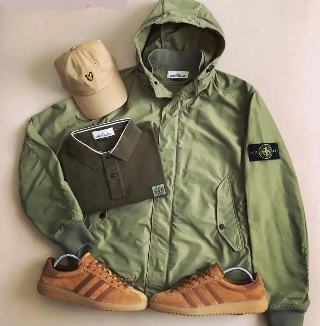 Casuals aesthetic — A flat lay featuring a Stone Island jacket, polo shirt, and Adidas Samba trainers perfectly encapsulates the signature garments and brands.