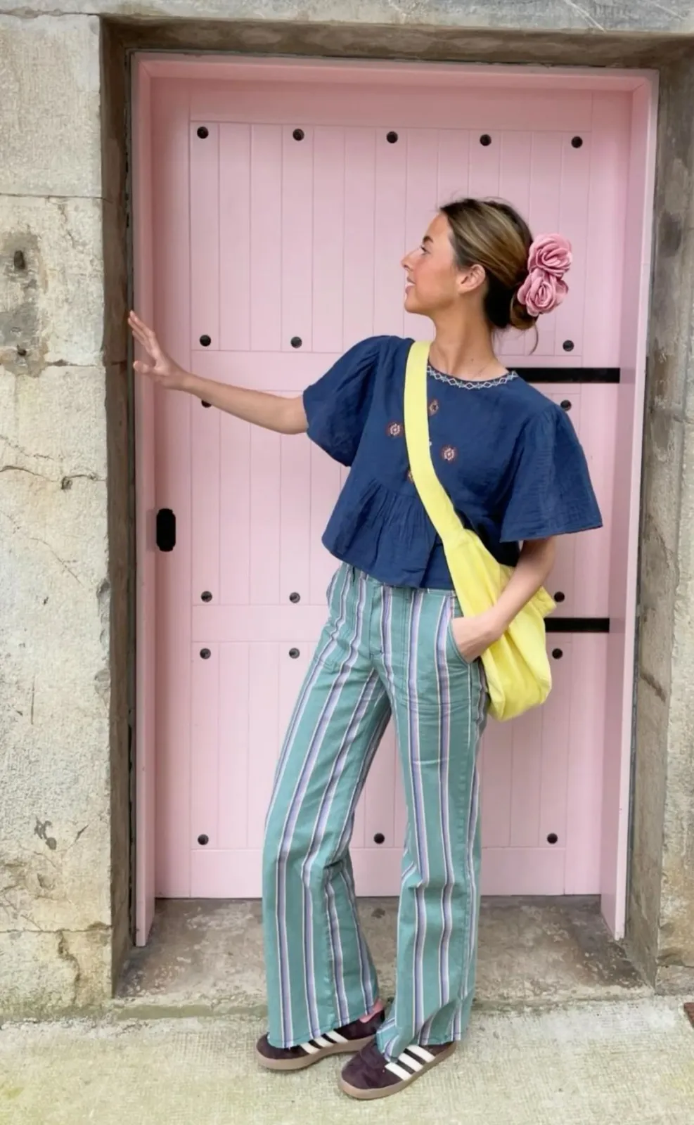 Cayetana aesthetic — The embroidered top, striped trousers, and flower in the hair are direct visual cues from the description, embodying the 'Madrid girl' aesthetic.