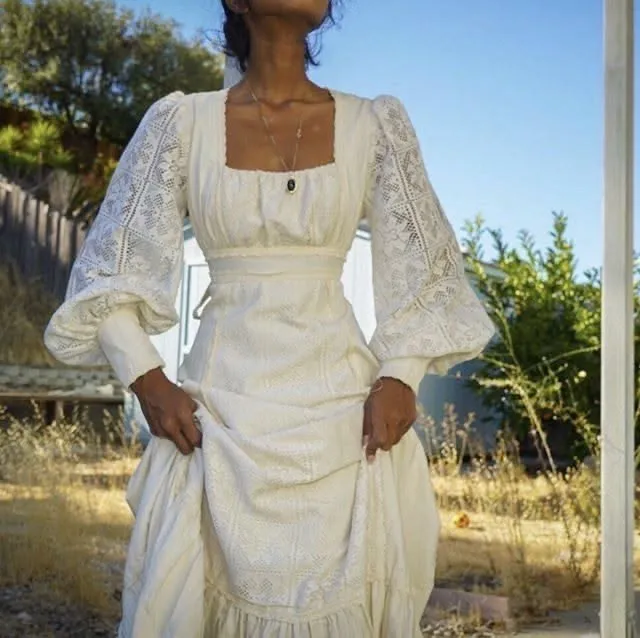 Cottagecore aesthetic — The square neckline, voluminous lace sleeves, and flowing natural fabric perfectly capture the prairie dress silhouette and romantic styling.