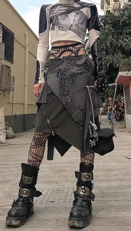 Cybersigilism aesthetic — This image perfectly captures the aesthetic with its layered asymmetric skirt featuring sigil prints, exposed midriff, fishnet tights, and heavy platform boots, all in the described palette.