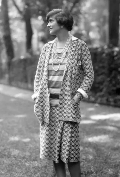 Garçonne aesthetic — Coco Chanel herself, in a signature jersey suit and pearls, is the quintessential example of the Garçonne aesthetic as described.