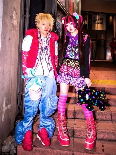 Harajuku Fashion aesthetic — This image perfectly captures the described Harajuku aesthetic with its DIY eclecticism, clashing colors (pink, purple, black), layered Sanrio-like motifs, and signature garments like pleated skirts and knee-high socks.