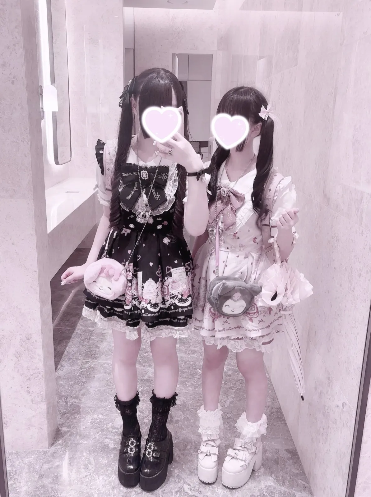 Jirai Kei aesthetic — Two individuals in full Jirai Kei attire, featuring black and pink dresses, long twin pigtails, and plush bag charms, strongly representing the aesthetic.