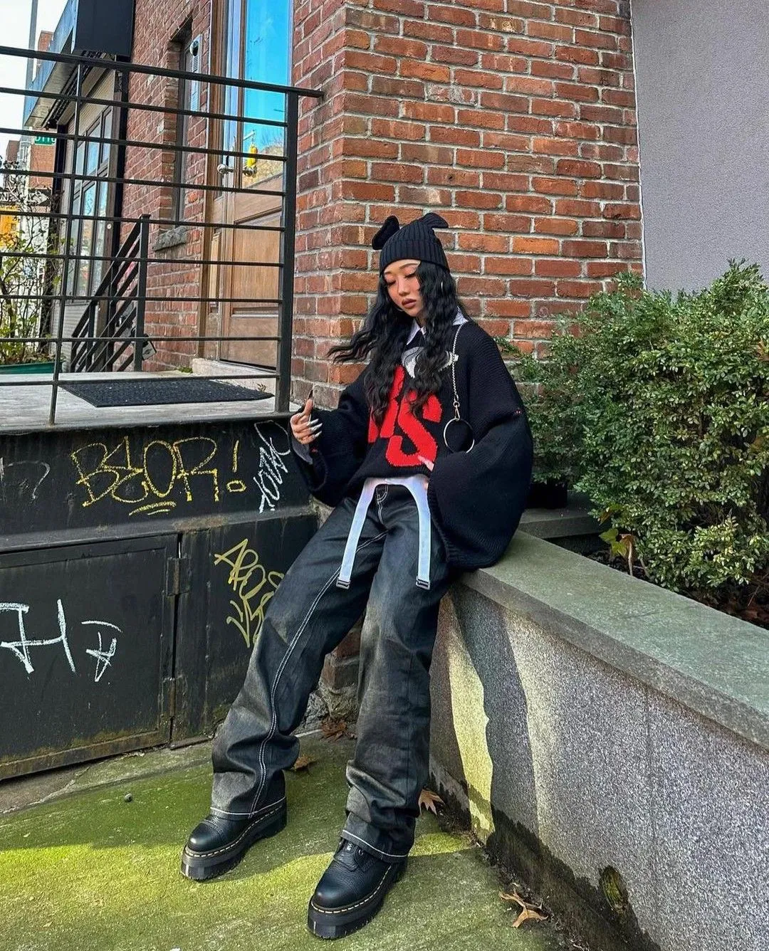 Naarmcore aesthetic — This image perfectly embodies Naarmcore with the head-to-toe black, oversized knit, baggy pants, Doc Martens, and beanie with ear details.