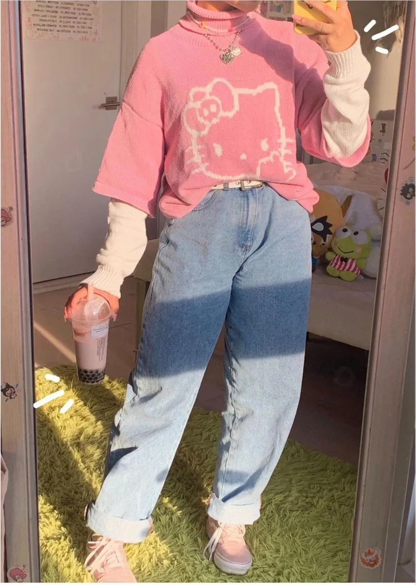 Sanriocore aesthetic — The image features a prominent Hello Kitty graphic sweater layered over a turtleneck, paired with baggy jeans and pink sneakers, embodying the Sanriocore aesthetic's focus on Sanrio character merchandise and Y2K-inspired silhouettes. The pastel color palette and the overall styling align well with the description.