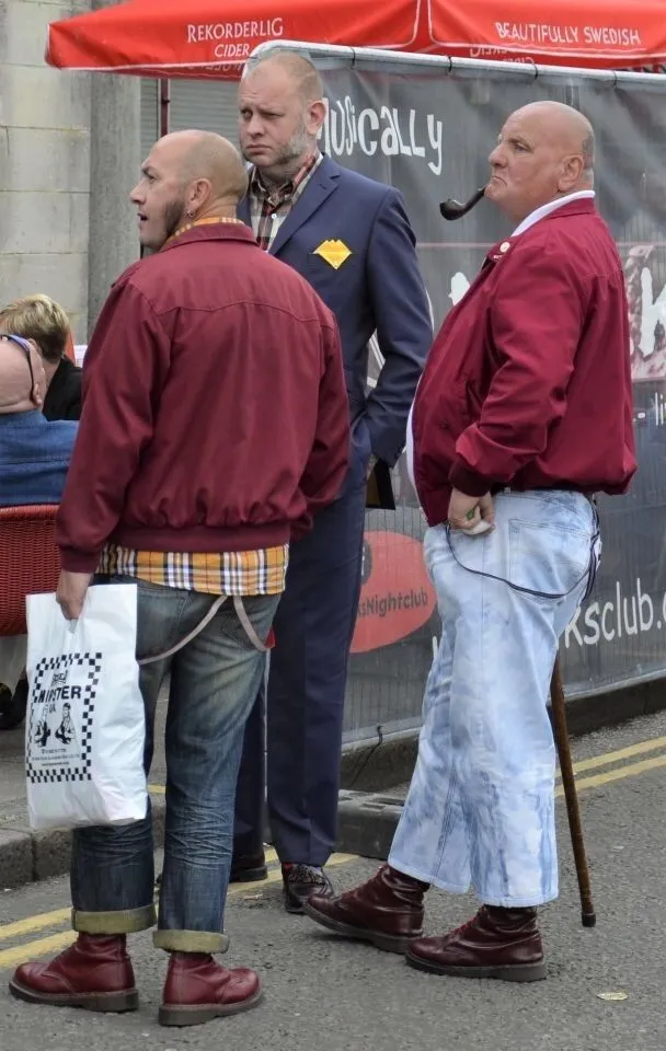 Skinhead (Traditional) aesthetic — The bomber jackets, braces, rolled-up jeans, and Doc Martens are all key elements of the traditional skinhead look.